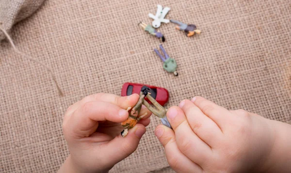 Anahtar, oyuncak arabalar, insan figürleri ve bir tuval üzerine bir torba