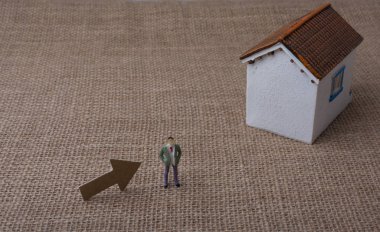 Manken evi ve tuval üzerinde bir adam figürü yanında bir ok.