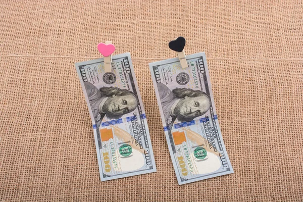 Dollar banknotes with a heart clip on a string — Stock Photo, Image