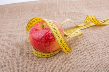 Bir ölçüm bandı üstünde o ile kırmızı elma