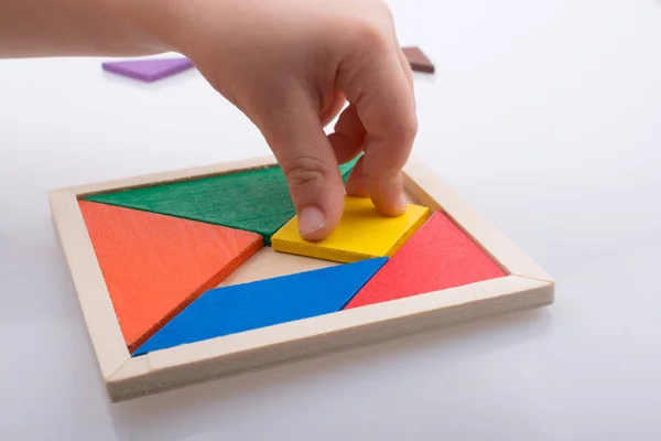 Hand houden van een ontbrekende stuk in een tangram puzzel — Stockfoto