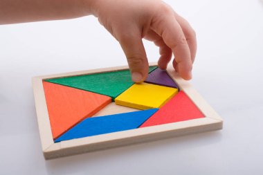 Tangram bulmacasının kayıp parçasını tutan el.