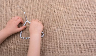 Çeşitli renk boncuk elinde dua