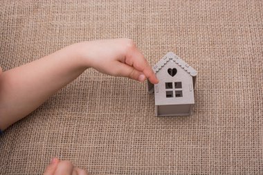 Bir tuval üzerine bir model ev tutan çocuk