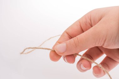 Kahverengi renk keten iş parçacığı elinde tutan el