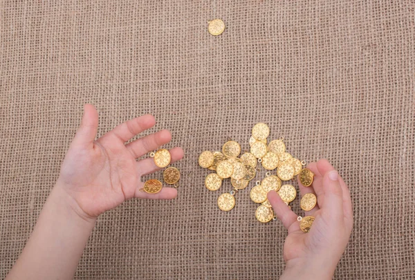 Un montón de monedas de oro falsas en la mano — Foto de Stock