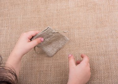 Çarşaftan yapılmış boş bir çuvalı tutan el.