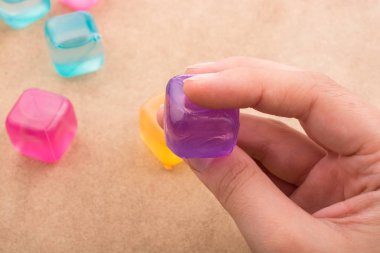 Bir sahte renkli buz küpü tutan el