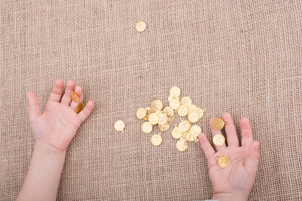 Un montón de monedas de oro falsas en la mano — Foto de Stock