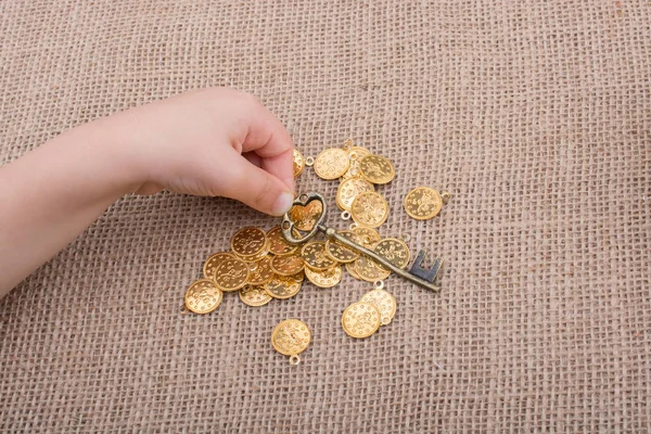 Mano Sosteniendo Una Llave Estilo Retro Sobre Monedas Oro Falsas — Foto de Stock