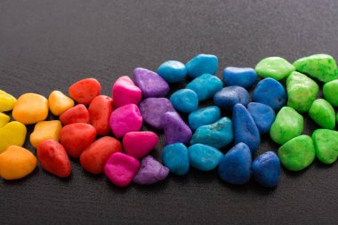 Siyah arkaplanda küçük renkli çakıl yığınları