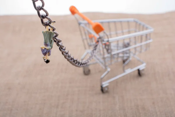 Vrouw Beeldje Gekoppeld Aan Een Winkelwagentje Met Ketting — Stockfoto