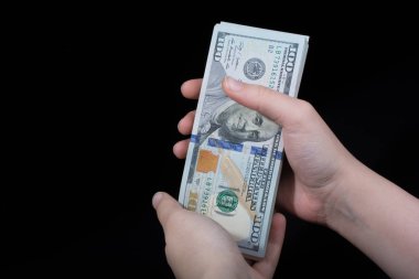 Beyaz arka planda el ele tutuşan Amerikan doları banknotları