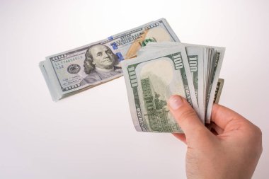 İnsan eli, Amerikan doları banknotunu beyaza izole edilmiş olarak tutuyor.