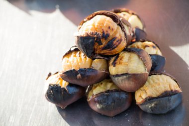 Sıcak ateşte kızartılmış organik kahverengi kestaneler.