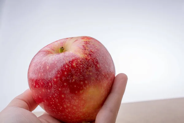 Mano Sosteniendo Una Manzana Roja Fresca Una Madera —  Fotos de Stock