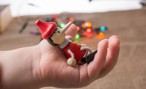 Drewniana Lalka Pinokio Ręku Siedzi Przed Światła — Zdjęcie stockowe