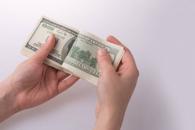 İnsan eli, Amerikan doları banknotunu beyaza izole edilmiş olarak tutuyor.