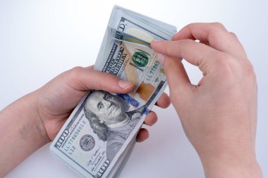 İnsan eli, Amerikan doları banknotunu beyaza izole edilmiş olarak tutuyor.
