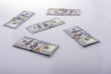 Beyaz zemin üzerine yerleştirilmiş Amerikan 100 dolarlık banknot demetleri