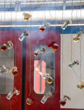 İplere asılı çiçekli bitkisel çay şişeleri