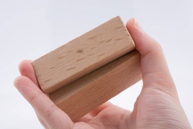 Beyaz arka plan üzerinde ahşap yapı taşları ile oynarken el