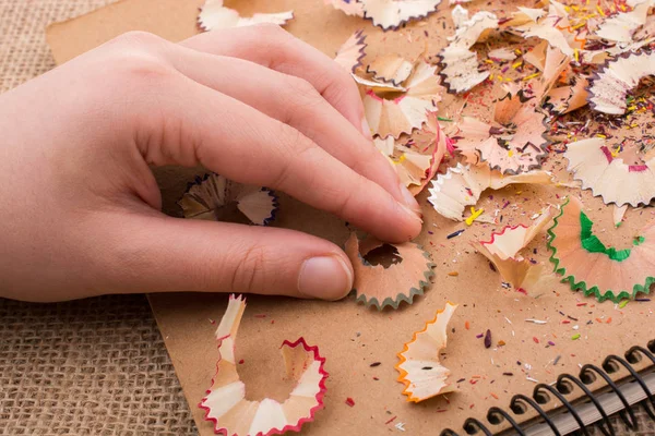 Bunte Bleistiftspäne Der Hand Auf Einem Notizbuch — Stockfoto