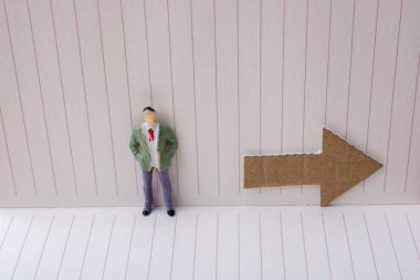 Heykelcik ve tuval üzerine bir defter kağıt ok