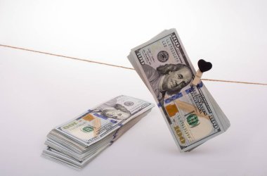 100 dolarlık banknotlar ve bir kalp klipsi.