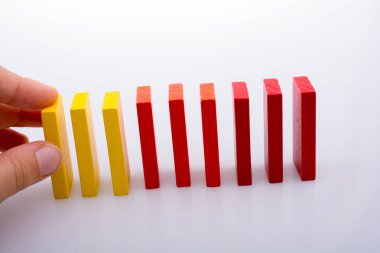 Beyaz arka planda el ele tutuşan renkli domino taşları