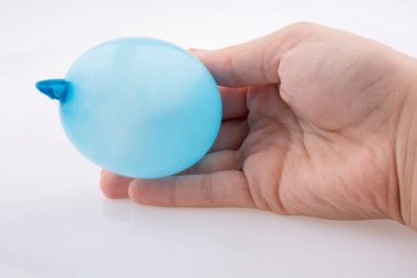 Beyaz bir arka plan üzerinde renkli küçük balon tutan el