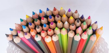 Beyaz zemin üzerinde bir vazoda renkli kalemler