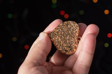 Kalp şekli simgesi üzerinde bokeh ışık elinde