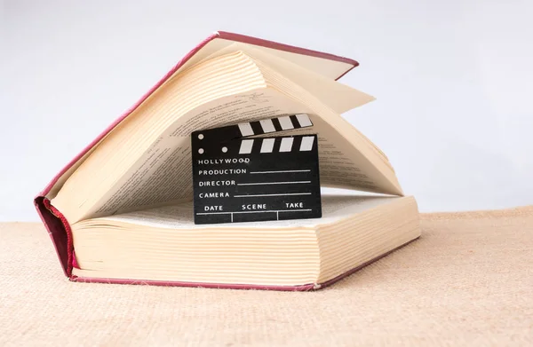 Film clapper yanında bir tuval arka plan üzerine bir kitap