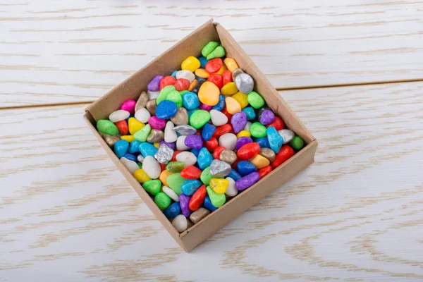 Petits Cailloux Colorés Dans Une Boîte Sur Texture Bois — Photo