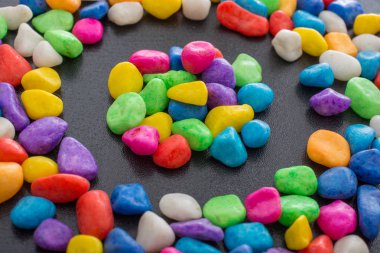 Siyah arkaplanda küçük renkli çakıl yığınları