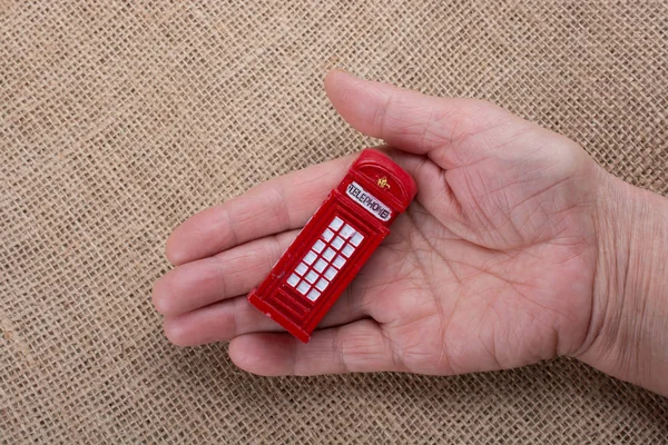 Hand Hält Eine Telefonzelle Auf Braunem Hintergrund — Stockfoto