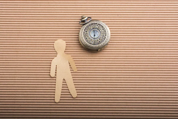 Paper man shape and a retro pocket watch