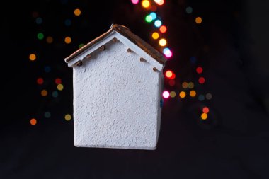 Koyu arkaplanda Bokeh ışıkları olan küçük model ev.