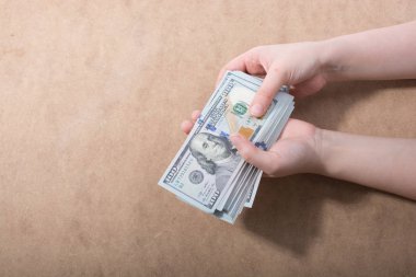 El ele tutuşan Amerikan doları banknotları ahşap arka planda izole edilmiş.