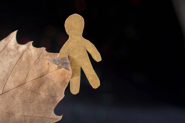 Paper man shape in hand on bokeh light background