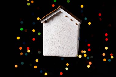 Koyu arkaplanda Bokeh ışıkları olan küçük model ev.