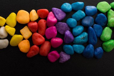 Siyah arkaplanda küçük renkli çakıl yığınları