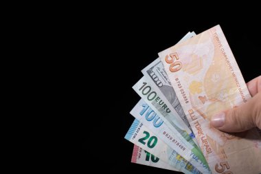 El ele tutuşan Amerikan doları banknotları siyah arka planda izole edilmiş.