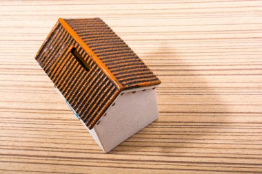 Küçük model ev ve parke arka planı.