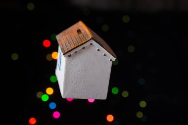 Bokeh ışıklı arka planda küçük bir model ev