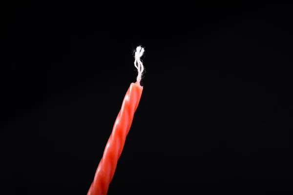 Colorful candle in hand on black background