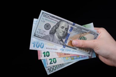El ele tutuşan Amerikan doları banknotları siyah arka planda izole edilmiş.