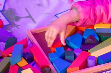 Renkli ahşap puzzle öğe elinde tutan el