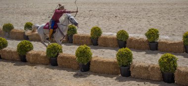 Osmanlı okçusu ata biner ve at sırtında ateş eder.